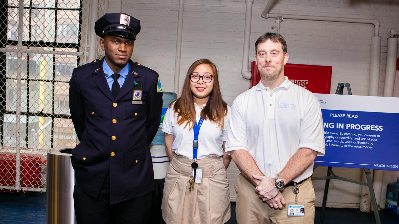 Commencement volunteers and Public Safety officer next to water station
