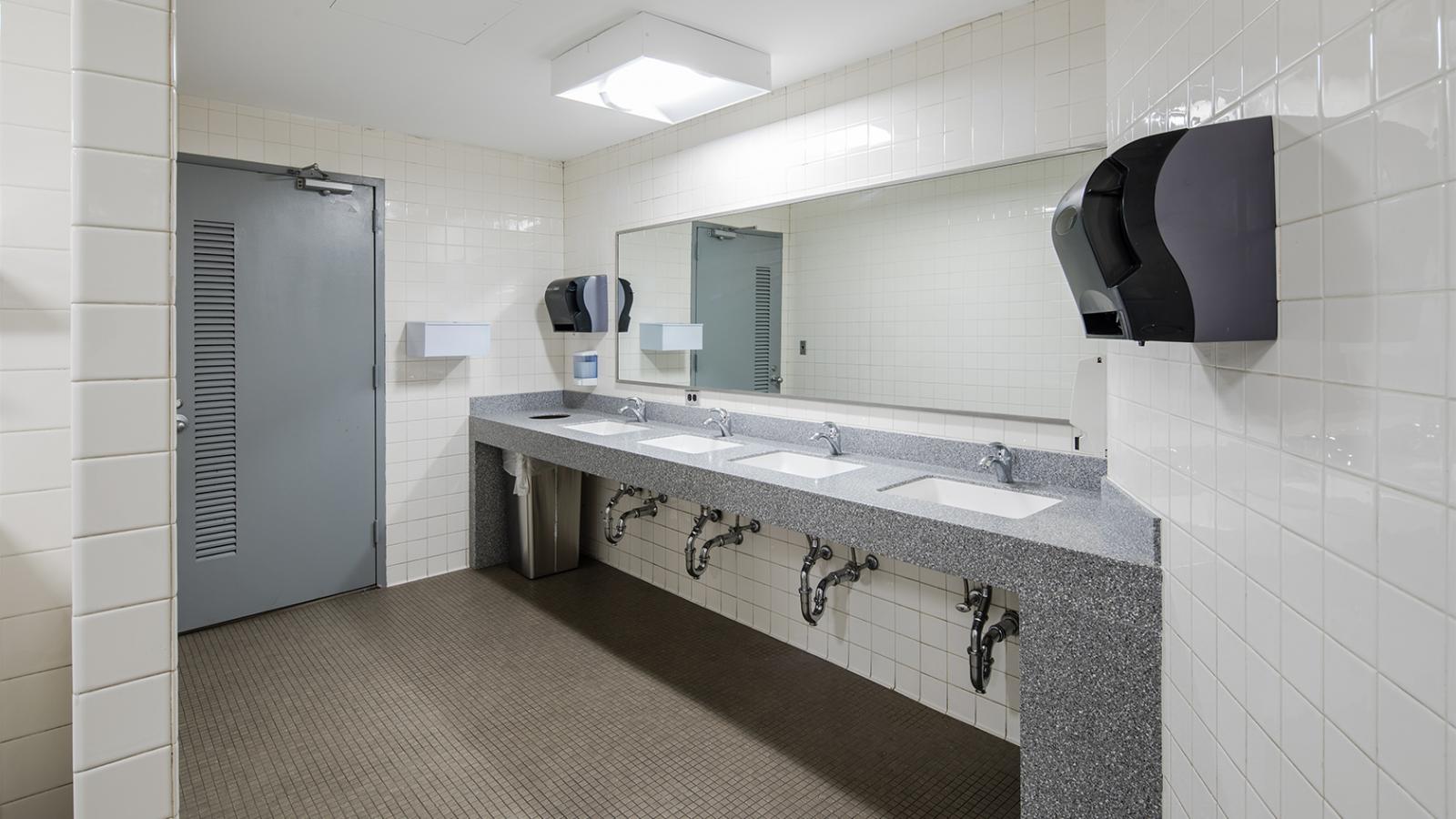 Restroom sink area after renovation with bright lighting and new countertop