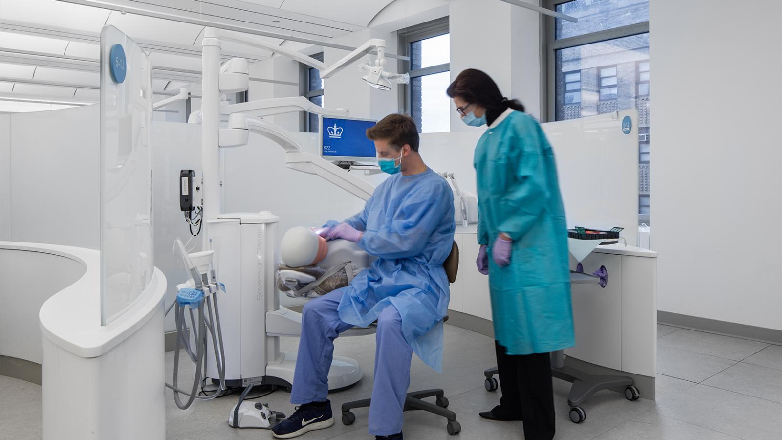 Operatory in dental clinic with student and doctor overseeing simulation dummy