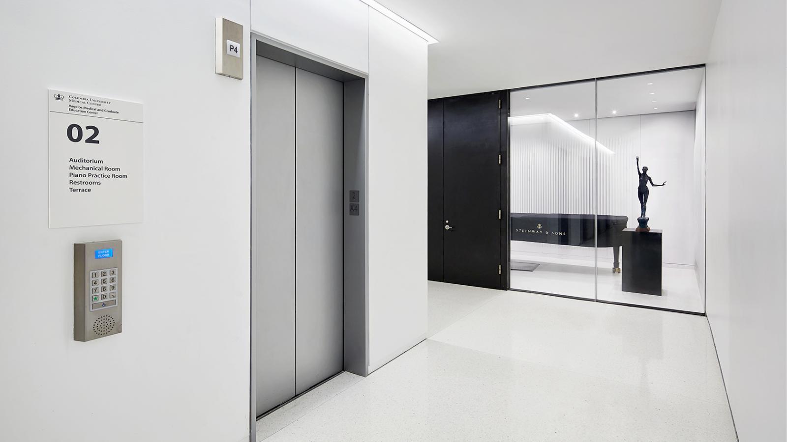 Elevator lobby in the Vagelos Education Center building, with piano room in the background