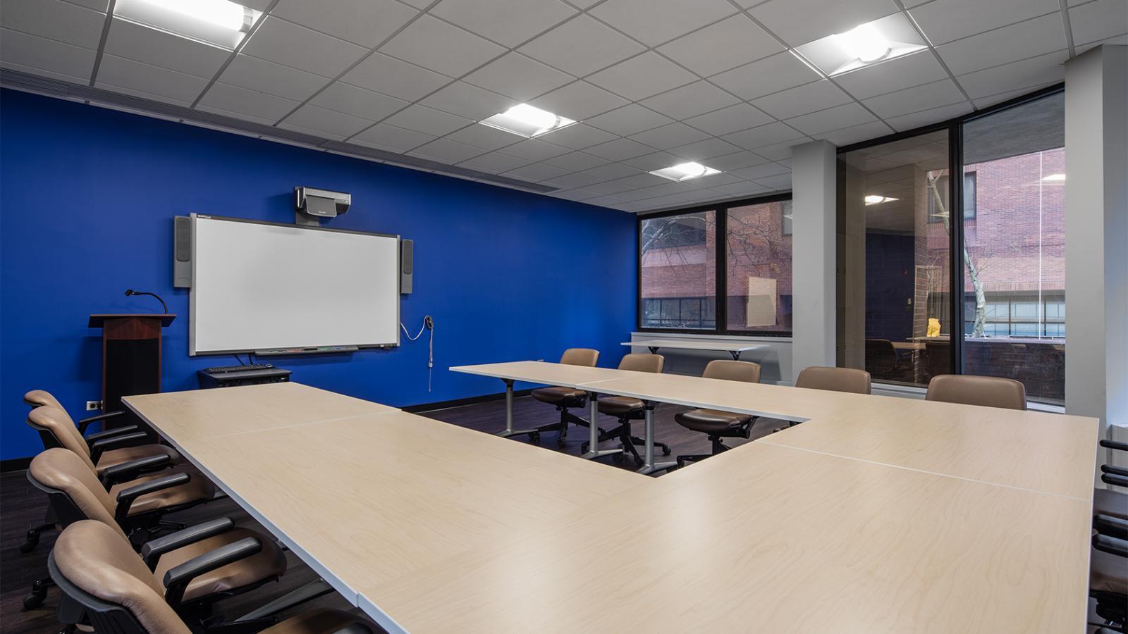 Conference Room 103A with U-shaped long table, chairs, and large windows, after renovation
