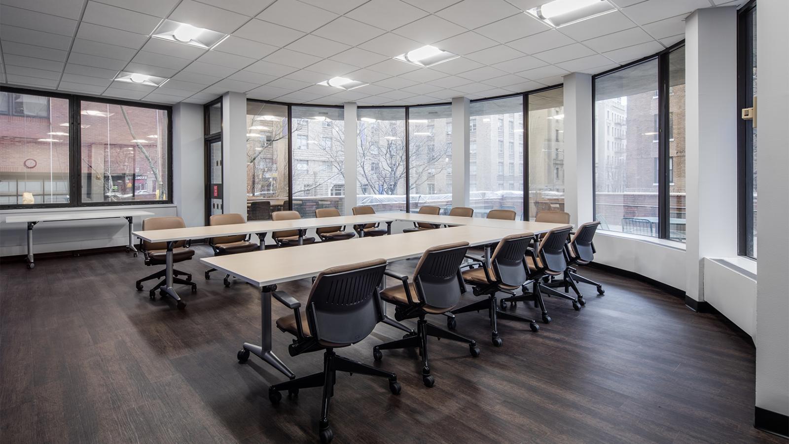 Conference Room 103A with U-shaped long table, chairs, and large windows, after renovation