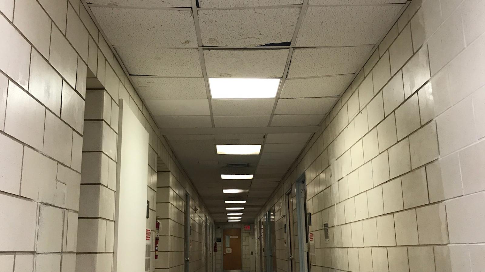 Black Building corridor ceiling with old tiles and bad lighting