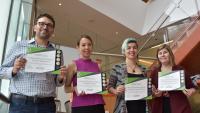 A photograph depicting four VP&S staff members, each holding a certification of recognition