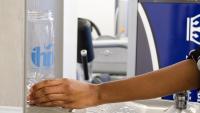 a person holding a water bottle at a water refill station