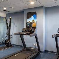 One SkiErg machine and two treadmills are on a blue floor with a mirror wall located to the left of the machines