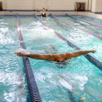 A man swimming in an indoor pool.