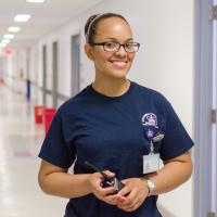A woman smiling in a hallway.