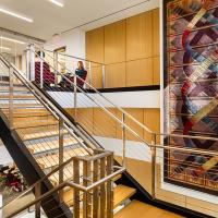 A large, original DNA carpet hangs near a staircase